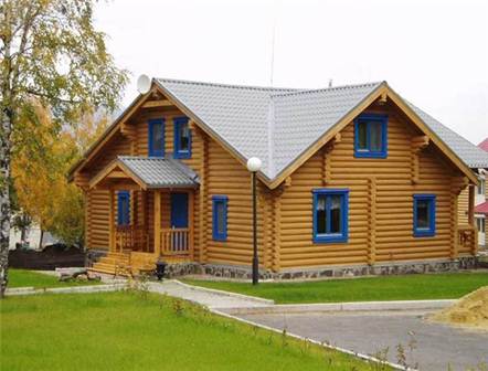 На фото деревянный дом из оцилиндрованного бревна – усадка